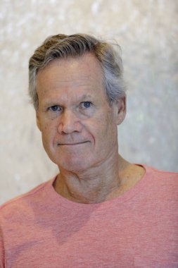 65 yaşındaki yakışıklı kameraya bakıyor