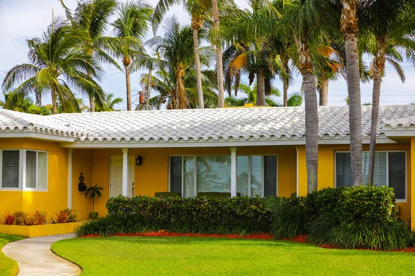 1950's Florida home painted yellow with green grass and palm tre — Stock Photo, Image