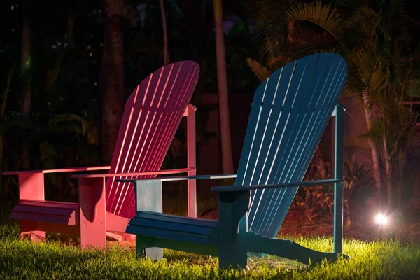 Niebieski i czerwony ponadgabarytowych krzeseł trawnikowych w nocy — Zdjęcie stockowe