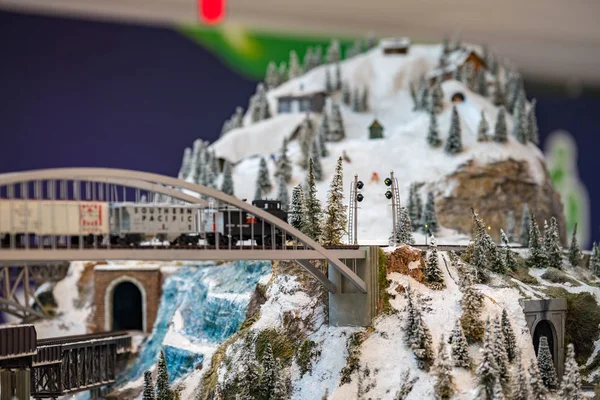 Miniature Toy Train Crossing Snowy Mountain Background — Stock Photo, Image