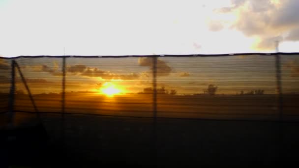 建設現場フェンスを通ってビデオ日没の動き — ストック動画