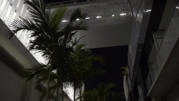 Passage piétonnier surplombant deux bâtiments. Caméra basculant vers le haut pour révéler prise de vue la nuit 