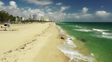 Sahilde alçak uçuş, dalgalar çarpıyor.