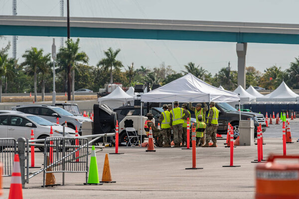 Miami, FL, USA - March 25, 2020: Military personnel discussing strategy at the Coronavirus Covid 119 testing site Miami FL USA