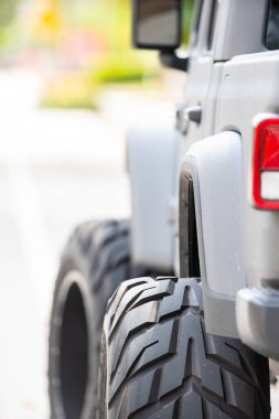 Büyük lastikleri olan zorlu bir off-road aracının detaylı fotoğrafı.