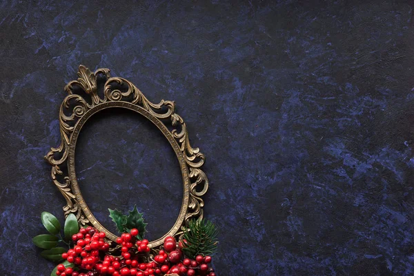 Vintage metal oval frame on a dark background with Christmas decoration