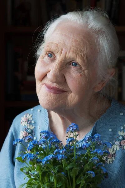 Oudere vrouw met bloemen — Stockfoto