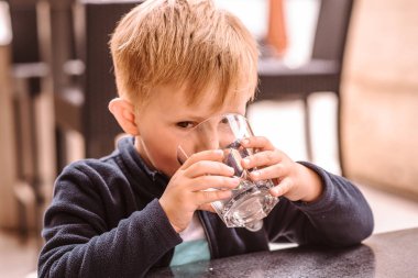 Su içen genç bir çocuk, açık hava portresi. Seçici odak