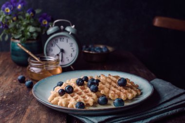 Kahvaltıda yaban mersinli Belçika waffle 'ı ve bal.