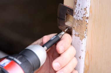 Adam bir güç aracı ile kapı tamiri