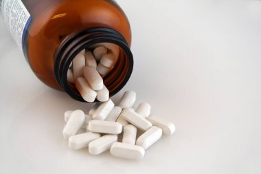 White Calcium Pills Pouring out of Bottle clipart