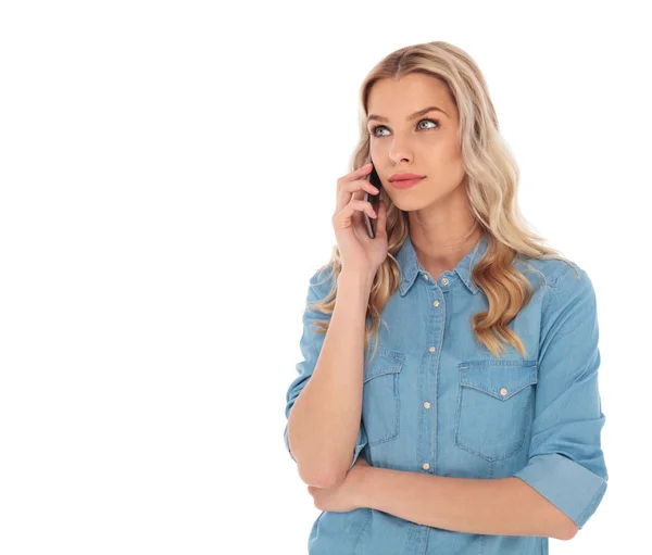 Pensive woman speaking on  phone is looking up to side — Stock Photo, Image