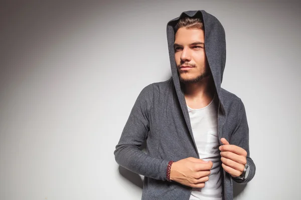 Young casual man with hoodie on looking to side — Stock Photo, Image