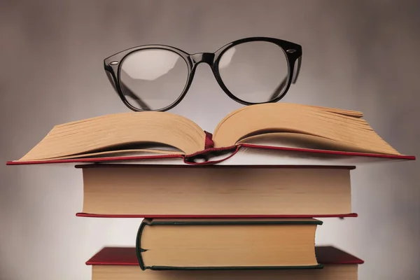 Glasses on top of a pile of books — Stock Photo, Image
