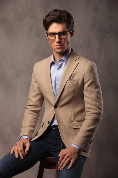 Moda mężczyzna w okularach i siedzi — Zdjęcie stockowe