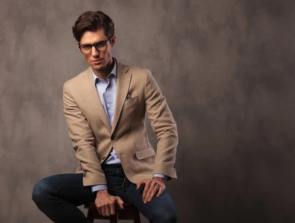 Sonriente hombre elegante sentado en el estudio — Foto de Stock