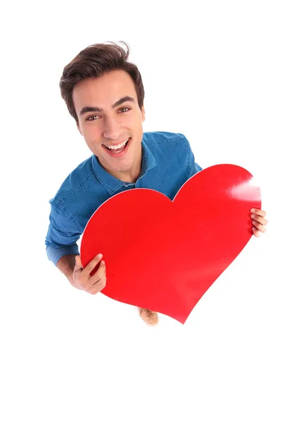 Hombre feliz sosteniendo un gran corazón rojo para el día de San Valentín — Foto de Stock