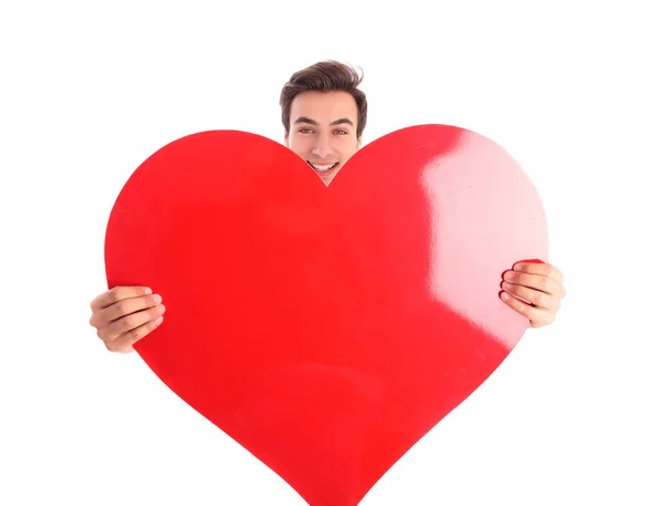 Joven hombre sonriente sosteniendo un gran corazón rojo —  Fotos de Stock