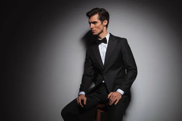 Seated man wearing tuxedo and bowtie, with copyspace — Stock Photo, Image
