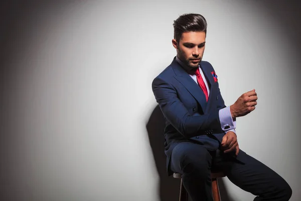 Sedící elegantní muž v obleku se ukázal při pohledu — Stock fotografie