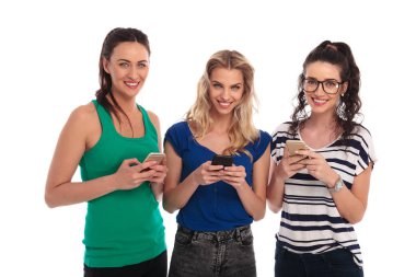 gülümseyen genç kadınlar manifatura üstünde onların telefon 