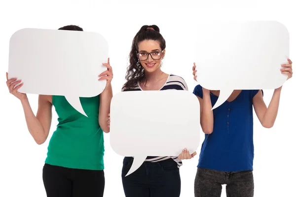 Three women holding speech bubbles, two covering faces — Stock Photo, Image