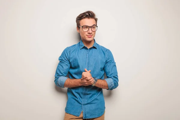 Junger, lässiger Mann mit Brille, der die Handflächen zusammenhält — Stockfoto