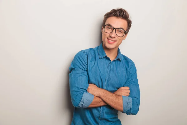 Lächelnder lässiger Mann mit Brille, die Hände über dem Kopf verschränkt — Stockfoto