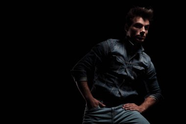 cebinde el ile sandalye üzerinde oturan dramatik genç adam