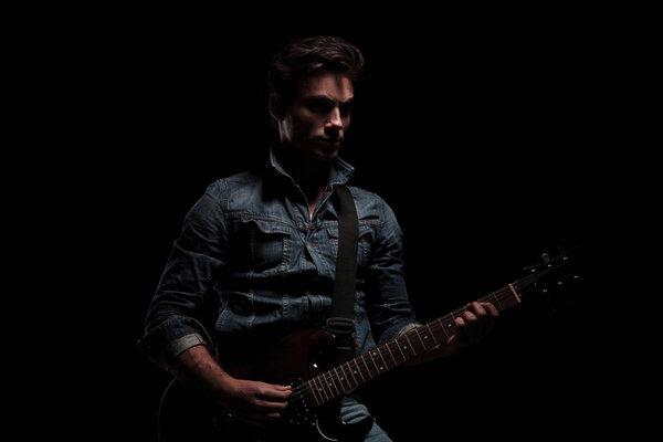 dramatic guitarist playing on his electric guitar