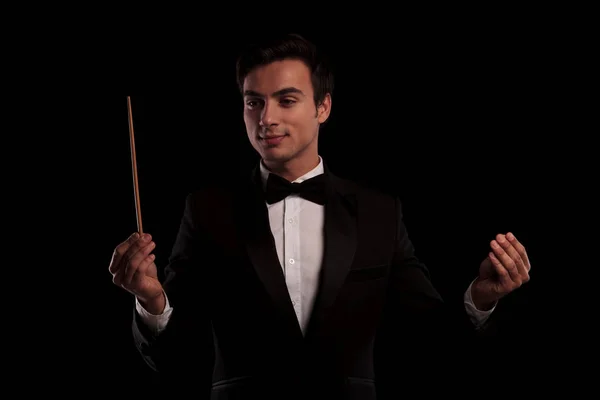 Елегантна людина в смокінгу диригує оркестром — стокове фото