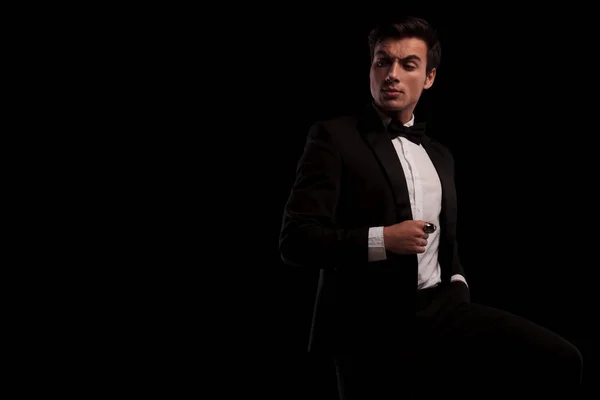 Arrogant young man in tuxedo and bowtie looking back — Stock Photo, Image