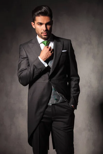 Young elegant man adjusting his green tie — Stock Photo, Image