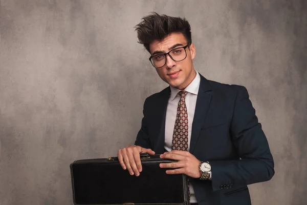Genç iş adamı giyen gözlük ve bir bavul tutar — Stok fotoğraf