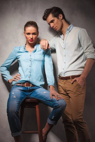 Woman sitting on stool while boyfriend leans on her shoulder — Stock Photo, Image