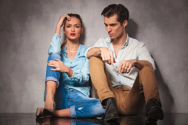 Young casual man looks away while sitting near girlfriend — Stock Photo, Image