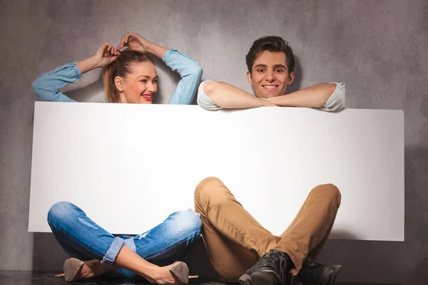 Happy  couple having fun while presenting a big blank board — Stock Photo, Image