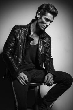 deri ceketli sandalye ve düşünüyor üzerinde oturan genç adam