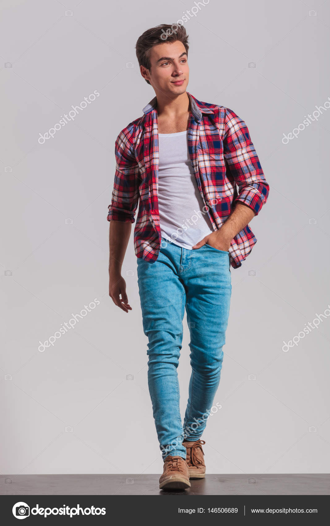 Man walking with one hand in pocket and looks away Stock Photo by