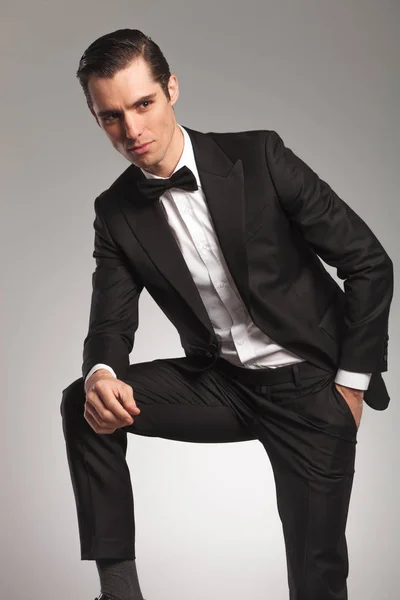 Elegancki mężczyzna noszenie tuxedo odpoczynku z ręką w kieszeni — Zdjęcie stockowe