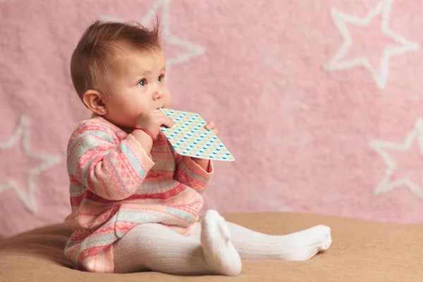 Vista lateral de una niña mordiendo una tarjeta —  Fotos de Stock