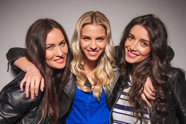 Tre skrattar unga kvinnor i skinnjackor — Stockfoto