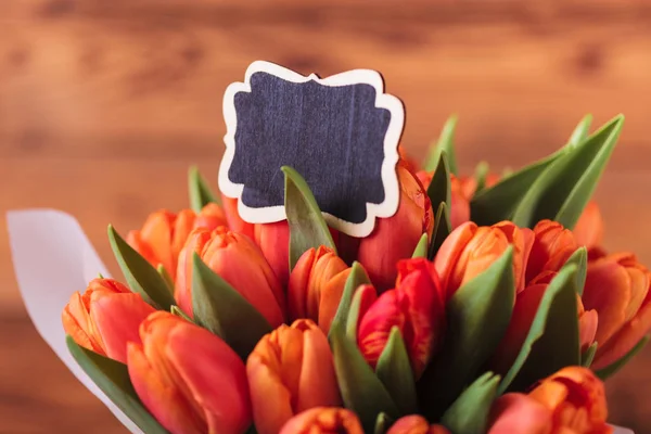 Mazzo di fiori di tulipani con una carta bianca — Foto Stock
