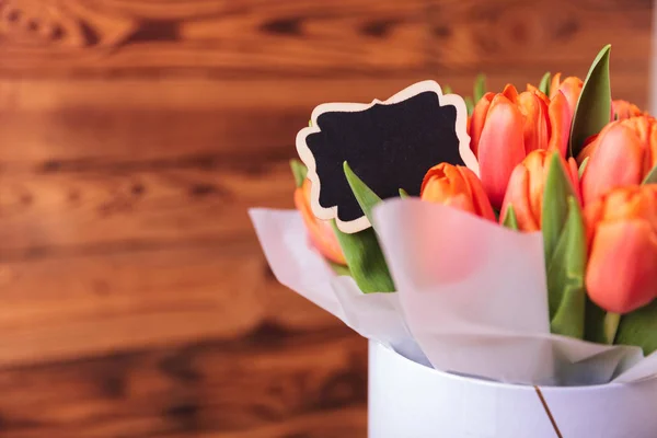 Scatola di tulipani arancioni con una carta per copyspace — Foto Stock