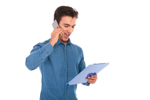 Estudiante leyendo notas del portapapeles y charlas por teléfono —  Fotos de Stock