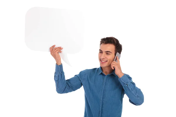 Счастливый случайный человек разговаривает по телефону и держит речевой пузырь — стоковое фото