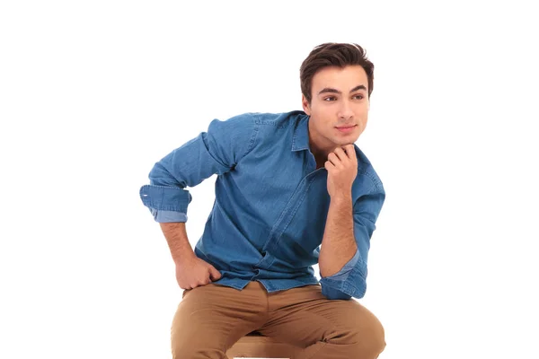 Sida av en casual ung man sitter och tänkande — Stockfoto