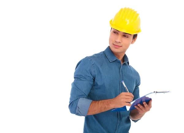 Visão lateral de um estudante de engenharia de construção escrevendo no clipb — Fotografia de Stock