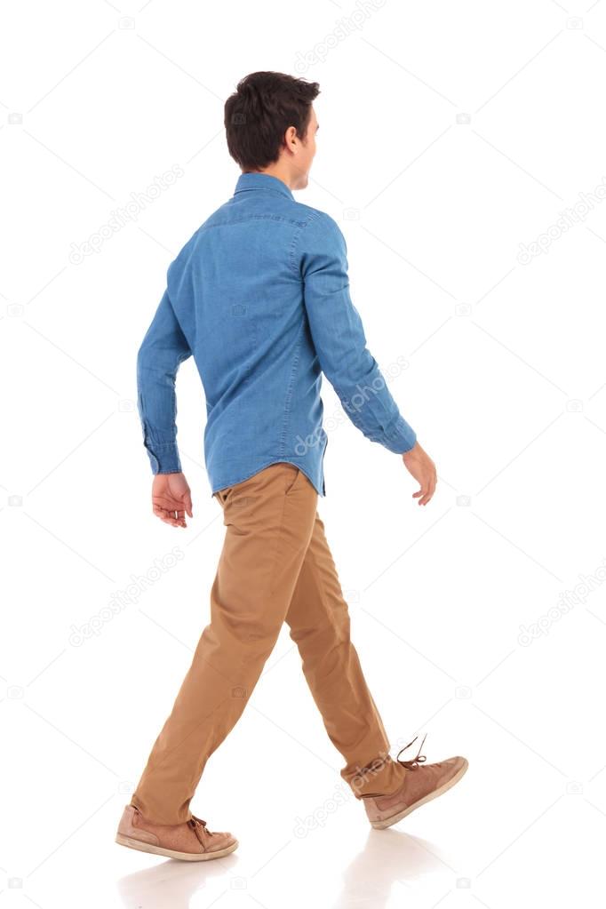 back side view of a walking young casual man
