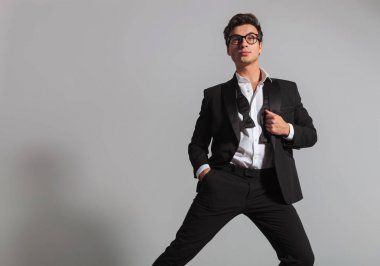 adam smokin ve geri alınan papyon tek ayak üstünde yaslanmış 